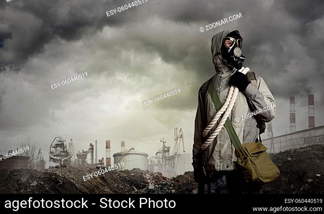 Man survivor in gas mask on industrial gray background