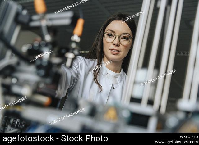 Close-up of female scientist examining equipment in laboratory at factory