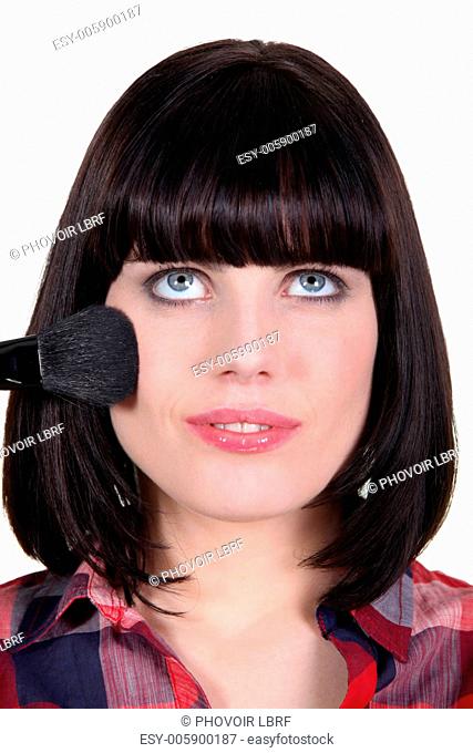 Brunette woman applying makeup