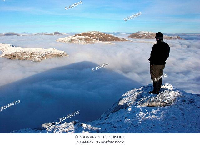 Hillwalker on Ben Challum looking across a cloud inversion to Beinn Achaladair & Beinn a'Chreachain