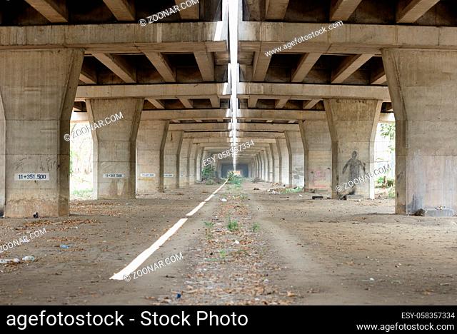 Portrait of concrete bridge pillars under the elevated tracks of highway