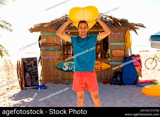 Caucasian man holding surf board on beach