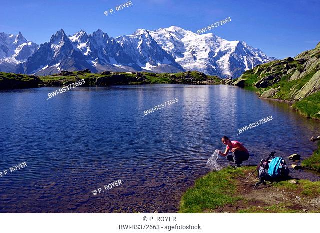 mountain hiker refreshing at Lac de Chesery, Mont Blanc in background, France, Haute-Savoie, Chamonix