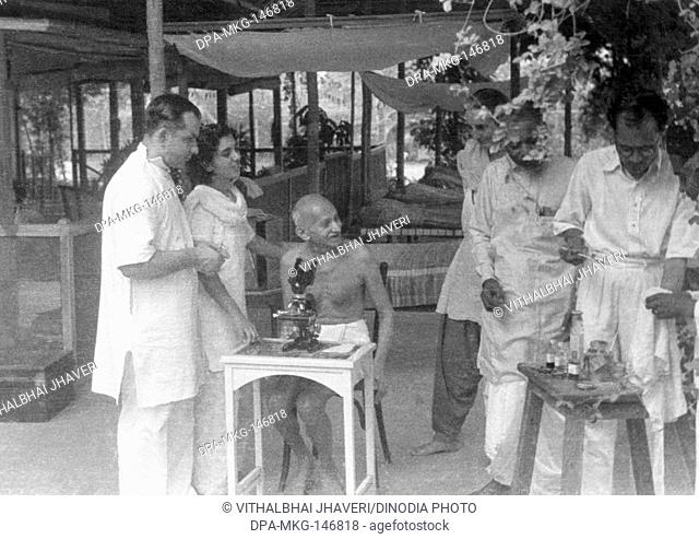 Mahatma Gandhi observing a hookworm cell through a microscope Gandhigram Sumati Morarjee's residence , Juhu Beach , Mumbai , May 1944 , Sushila Nayar