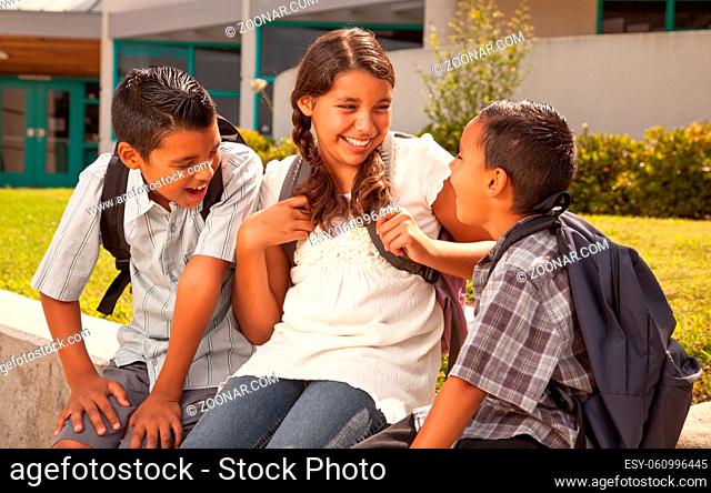 Young Hispanic Student Children Wearing Backpacks On School Campus