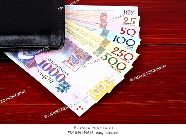 Haitian money in the black wallet on a wooden background