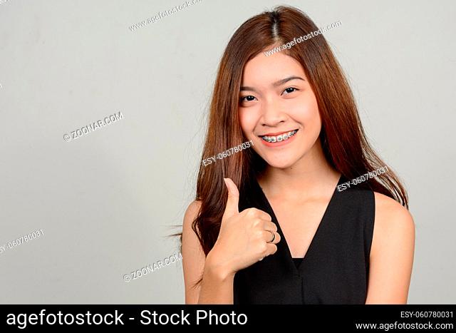 Studio shot of young beautiful Asian woman against white background