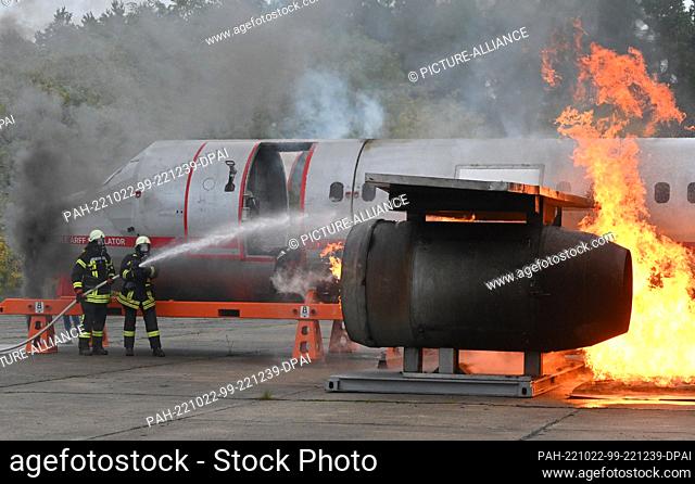 22 October 2022, Brandenburg, Neuhardenberg: Firefighters extinguish an engine next to the fuselage of a replica of an Airbus A 320 during a civil protection...