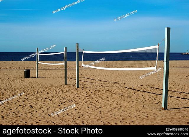 Ein Beachvolleyballfeld mit einem Volleyballnetz am Strand von Long Beach mit Blick auf den Ozean
