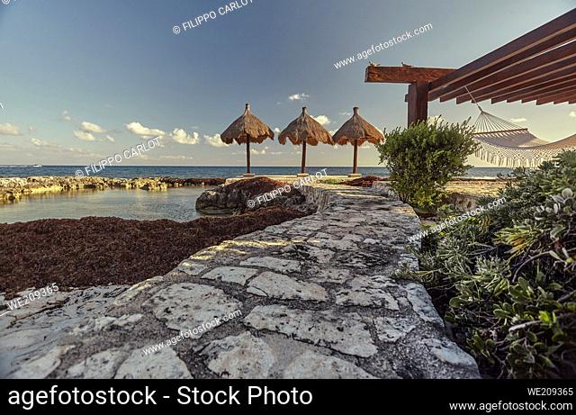Stone driveway leads to the gazemo with the hammocks facing the sea in Puerto Aventuras in mexico