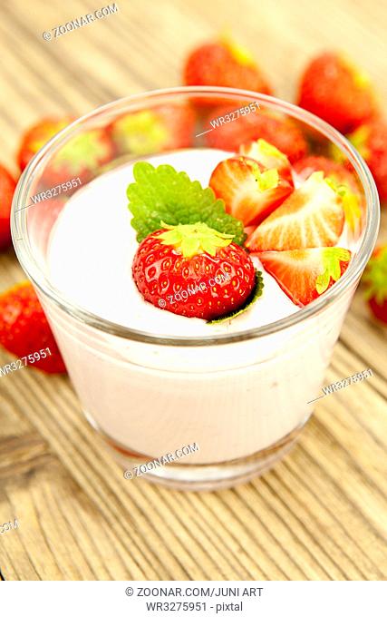 frischer erdbeer joghurt shake mit erdbeeren auf einem Holztisch