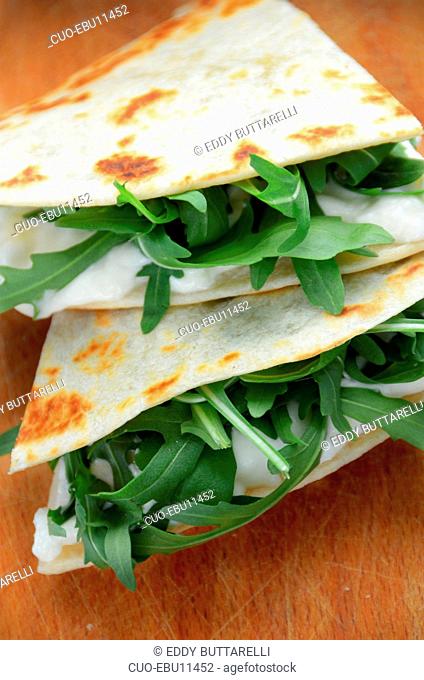 Piadina from Emilia Romagna flatbread with squacquerone cheese and rucola salad, Italy, Europe