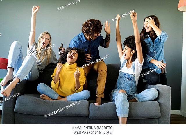Excited fans watching tv and cheering