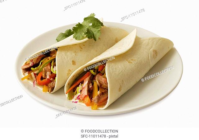 Two Beef Tacos in Flour Tortillas on a White Plate, White Background