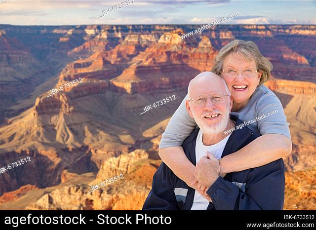 Happy, hugging senior couple posing on the edge of the grand canyon