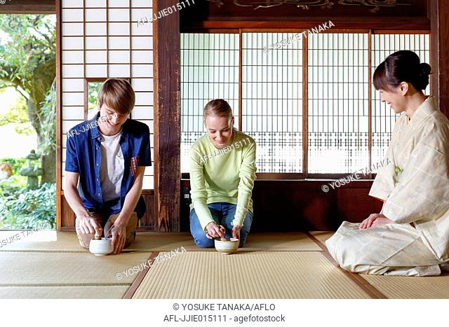 Caucasian couple enjoying tea ceremony at traditional Japanese house