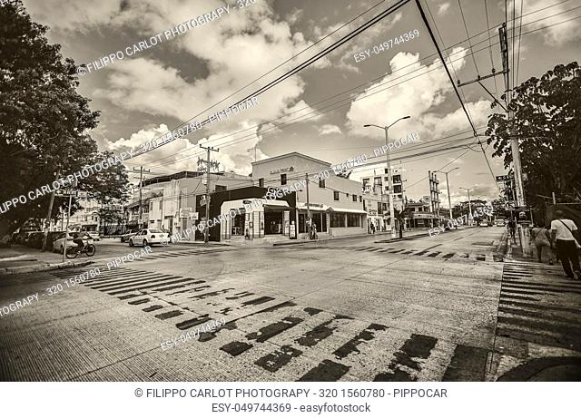 Black and white photo of a cross between streets of playa del Carmen in Mexico completely empty in wide angle shot