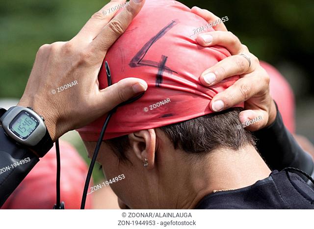 Triathlon swimmer adjusting her cap