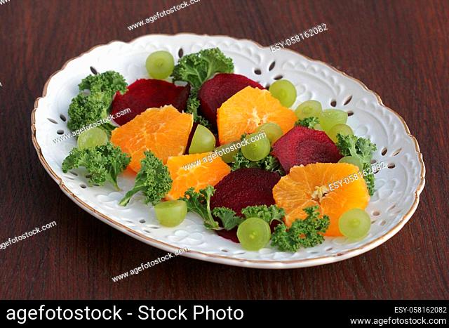 Fresh salad with beet, orange, kale and grapes