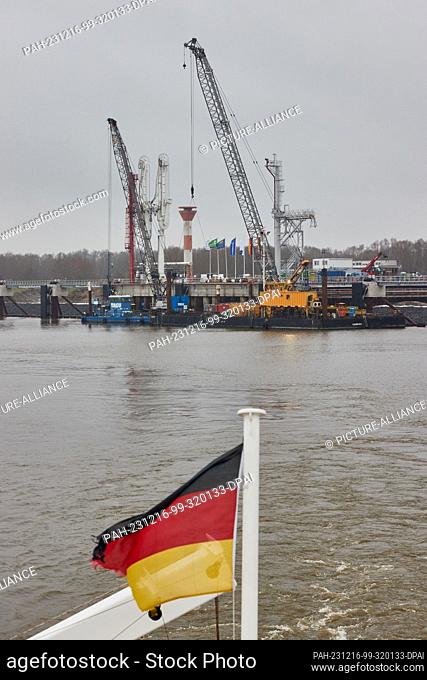 16 December 2023, Lower Saxony, Stade: View of the jetty for liquefied gases (AVG). The flag of Germany can be seen in the foreground on the MS Helgoland