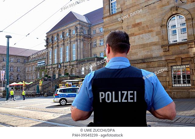 A police officer stands in front of the town hall which has been evacuated and closed due to a bomb threat in Kassel, Germany, 16 May 2013