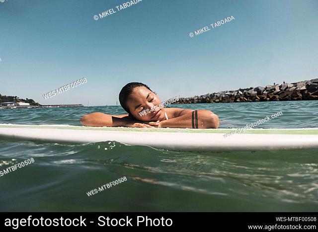 Female surfer lying on surfboard