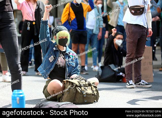 29 May 2021, North Rhine-Westphalia, Duesseldorf: A demonstrator holds up her fist. The demonstration of the ""Black Lives Matter"" movement takes place on the...