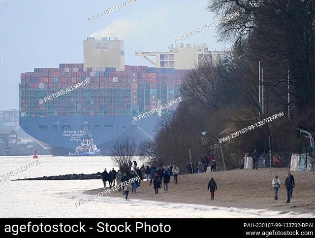 PRODUCTION - 03 January 2023, Hamburg: A huge container ship sails on the Elbe toward the North Sea. The Port of Hamburg on the Elbe is a universal port for all...