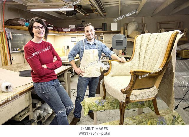 A young Caucasian couple working on a chair as a team of upholsterers