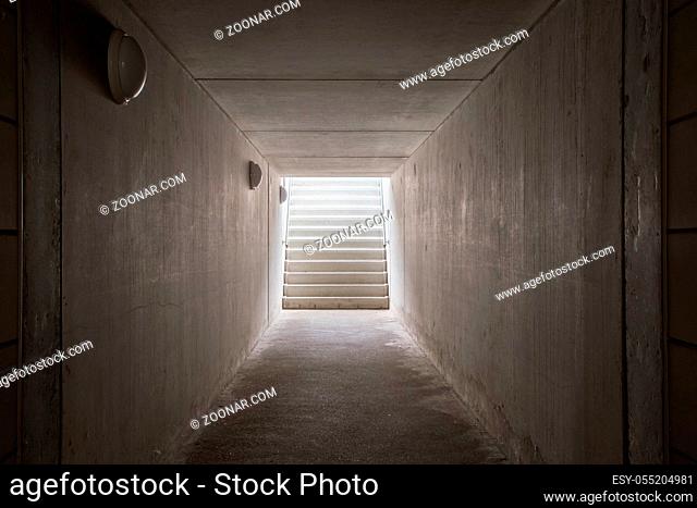Underground passage with stairs in the glowing end darkness