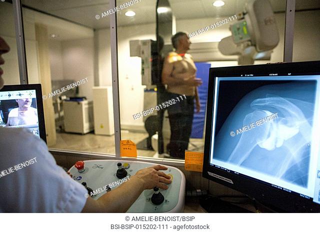 Reportage in a radiology centre in Haute-Savoie, France. A technician carries out an arthography of the shoulder with osteoarthritis