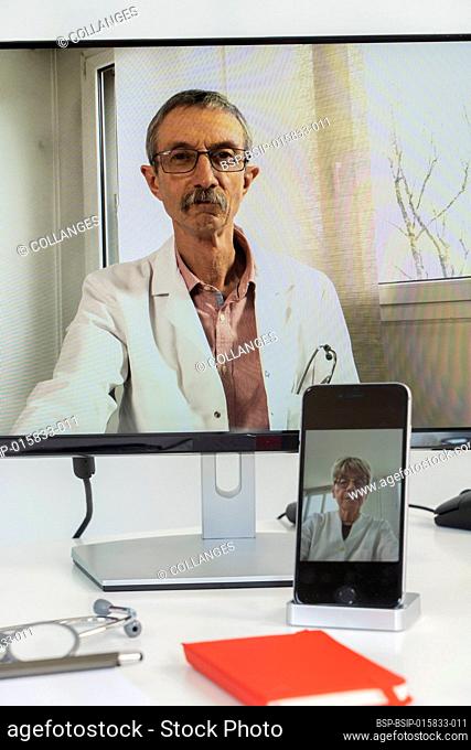 Close-up of a teleconsultation between two doctors, one of whom is filmed with his phone