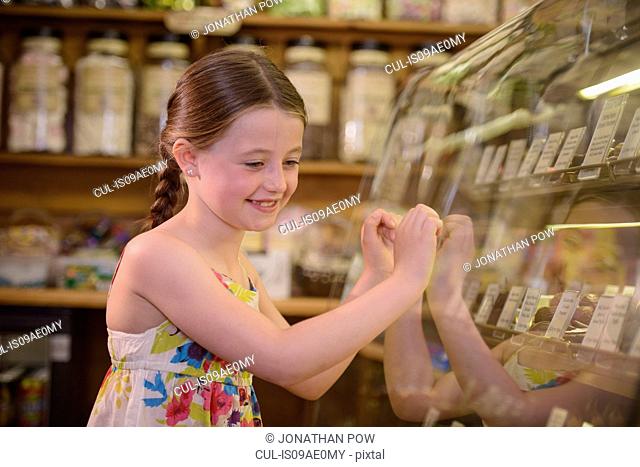 Girl looking at sweets in traditional sweet shop