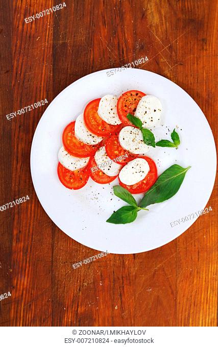 Mozzarella cheese tomato and basil on a plate