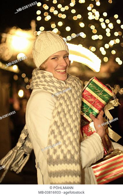 Christmas market, woman, winter clothing, Christmas gifts, carries, laughing, Half portrait, evening,  Series, 30-40 years, gaze camera, rope cap, cap, Scarf