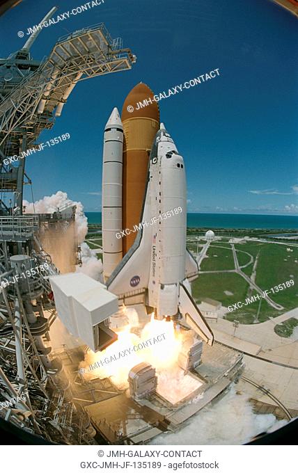 Captured on film by a remote camera equipped with a special fish-eye lens, the Space Shuttle Discovery and its seven-member crew launch at 2:38 p.m