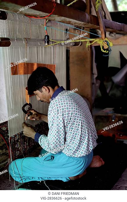 INDIA, SRINAGAR, 22.06.2010, A Kashmiri carpet weaver hand ties knots on a Kashmiri carpet. One carpet can consist of 400 knots hand tied per square inch and...