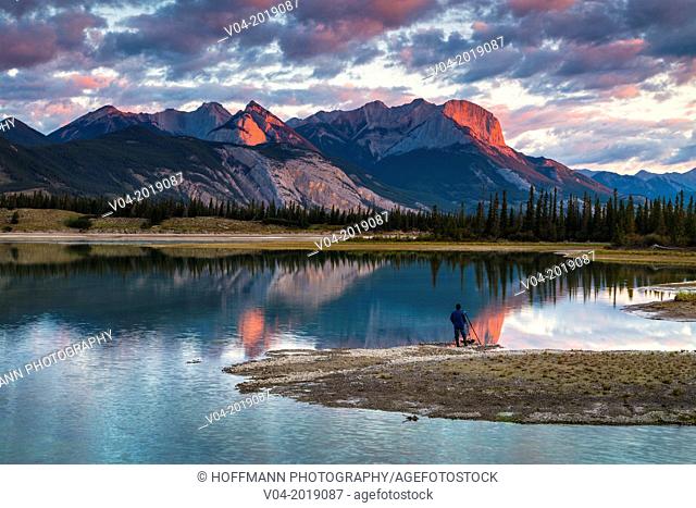 Photographer watching the sunrise over the Canadian Rocky Mountains in the Jasper National Park, Alberta, Canada
