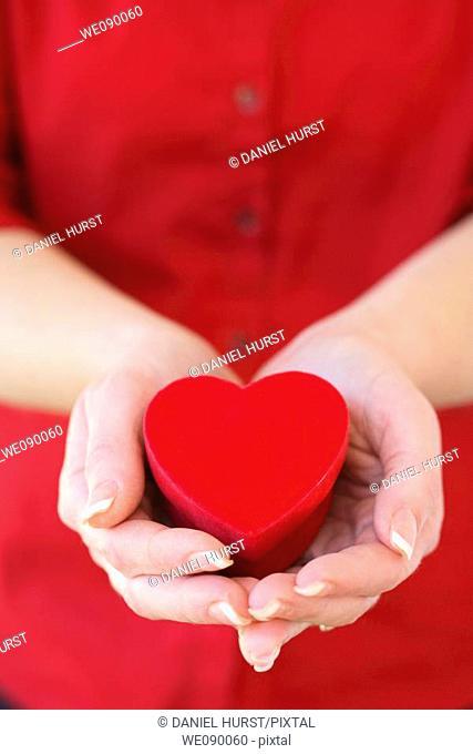 Hands holding heart shaped box