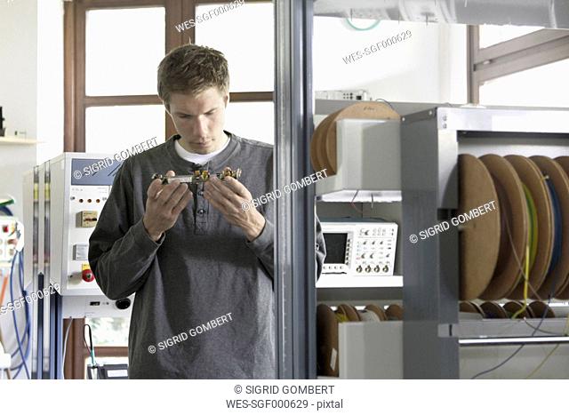 Young man working in an electronics workshop
