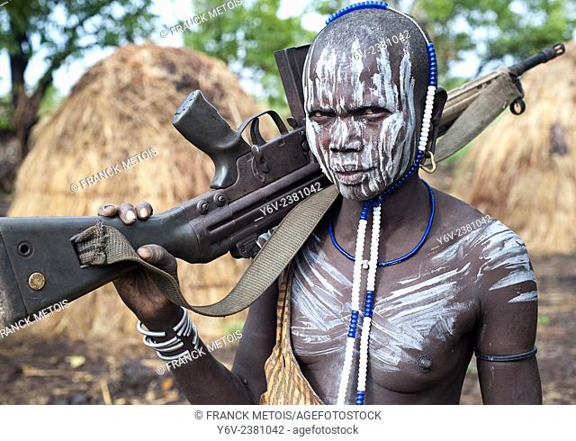 Woman belonging to the Mursi tribe. Omo valley ( Ethiopia). She is holding a Kalashnikov