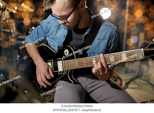 man playing guitar at studio or concert