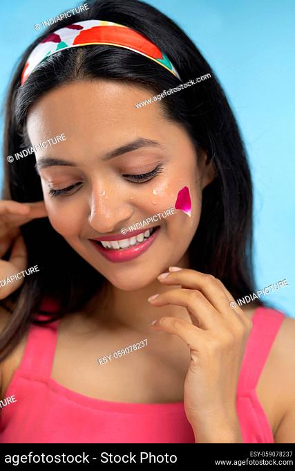 Portrait of beautiful woman Smiling with Red Rose Leave on her face