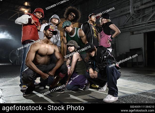 Multi-ethnic break-dancers posing in warehouse