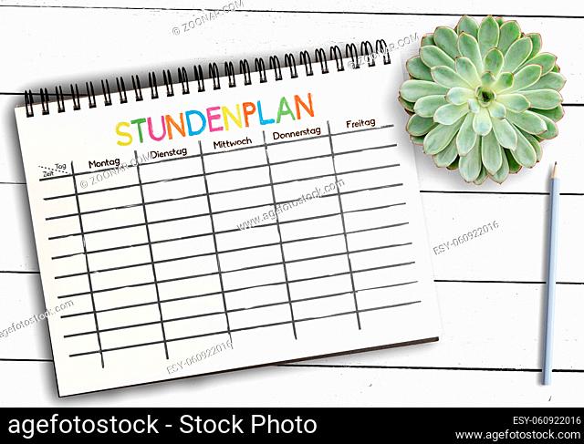 top view of class schedule or timetable template with word STUNDENPLAN, German for schedule, on notepad against rustic white wooden table