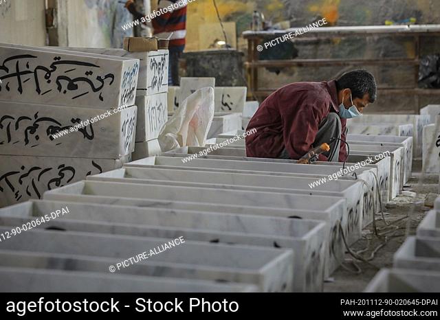 12 November 2020, Iraq, Najaf: A worker assembles gravestones at a workshop for making coffins, gravestones and markers near the Wadi al-Salam (Valley of...