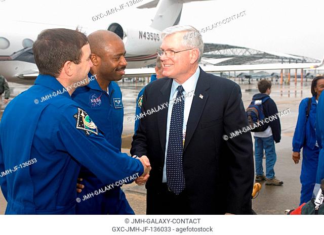 Johnson Space Center's (JSC) director Michael L. Coats (right) greets astronauts Rex Walheim (left) and Leland Melvin, STS-122 mission specialists