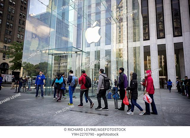 An Apple employee lets in a small group of customers from the line at the Apple store on Fifth Avenue in New York to purchase the new iPhone 6 and 6 Plus on on...