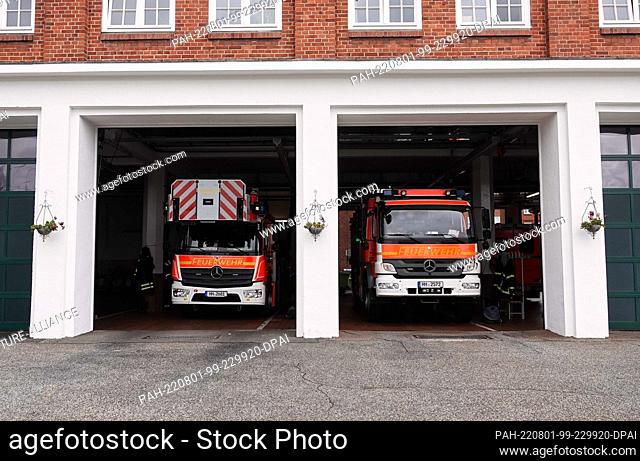 PRODUCTION - 22 July 2022, Hamburg: A turntable ladder and a fire engine stand in a vehicle hall at the Berliner Tor fire and rescue station