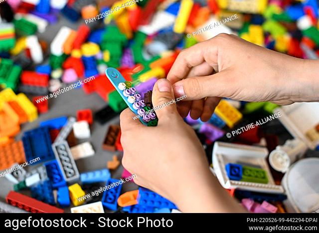 25 May 2022, Bavaria, Munich: A child builds with Lego bricks, taken at the Lego Summer Birthday Bash anniversary event. Lego celebrates 90 years of company...